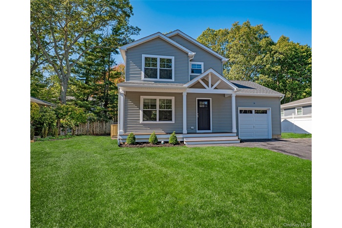 View of front facade with a porch, asphalt driveway, a garage, and a shingled roof