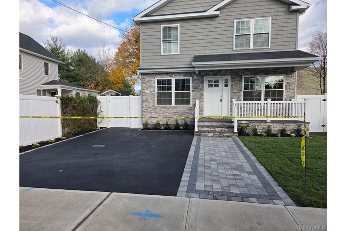 Craftsman house with a gate, stone siding, and covered porch