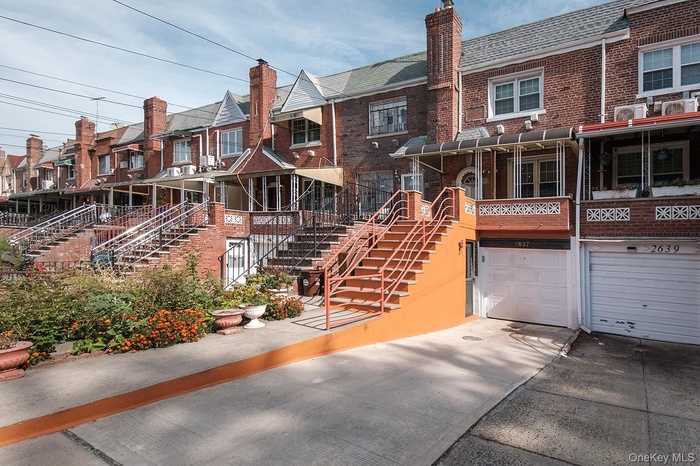 View of front of home featuring a residential view, brick siding, stairs, and a chimney
