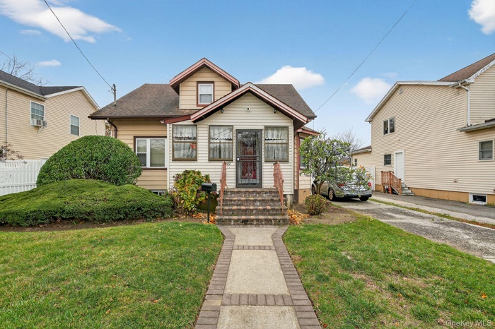 Bungalow featuring a shingled roof and entry steps