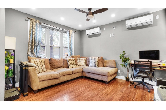 Living area with an office area, ceiling fan, hardwood / wood-style floors, an AC wall unit, and recessed lighting