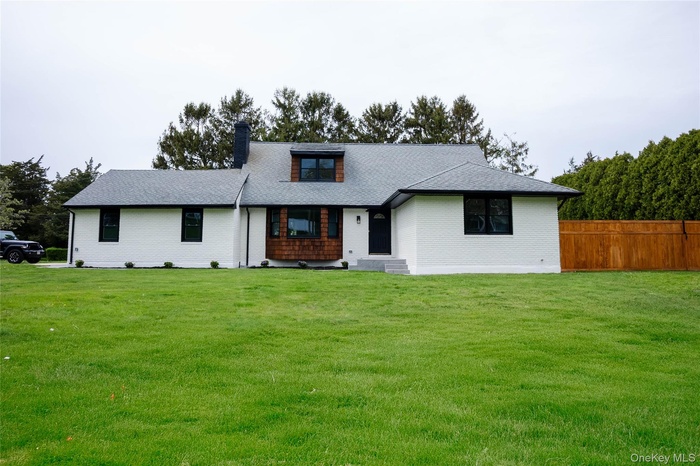 View of front of home with a chimney and brick siding