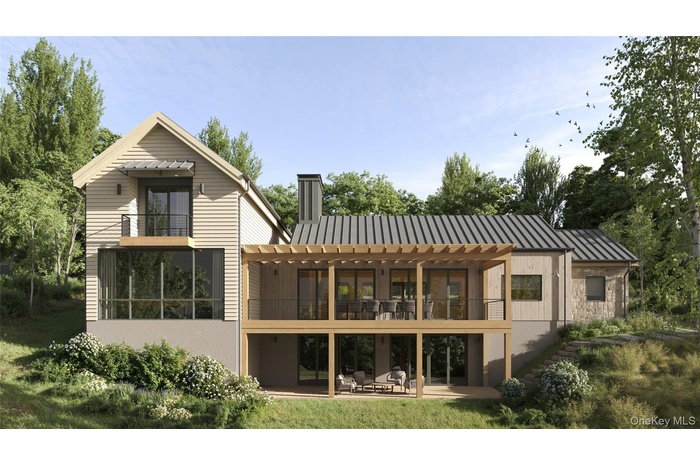 Rear view of property with a balcony, a patio, a metal roof, and a chimney