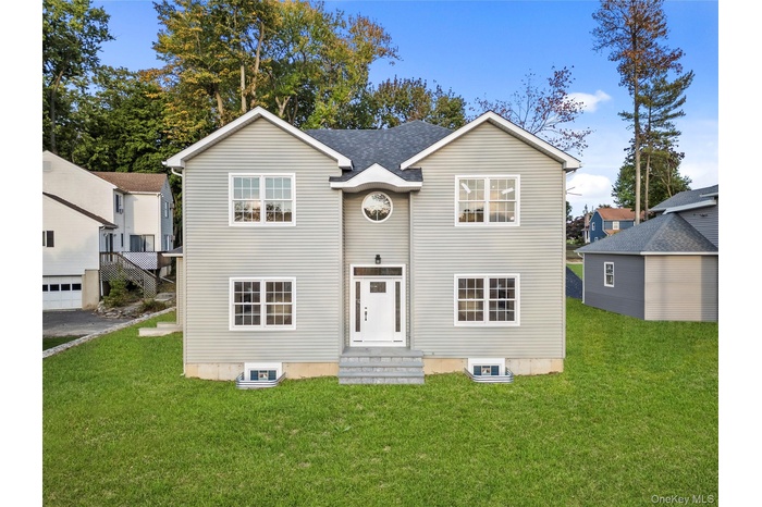 Traditional-style home with a front yard and entry steps