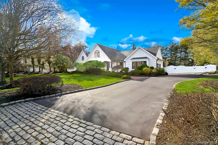 View of front of home featuring a gate, curved driveway, and board and batten siding