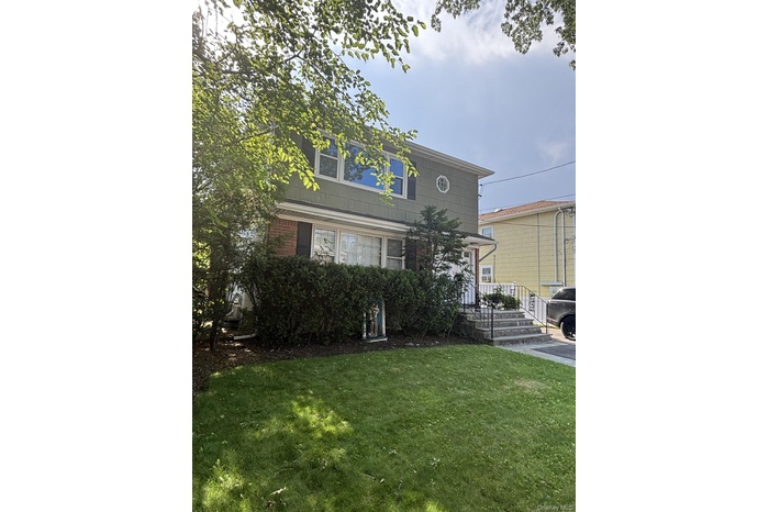 View of front of house featuring a front yard and brick siding