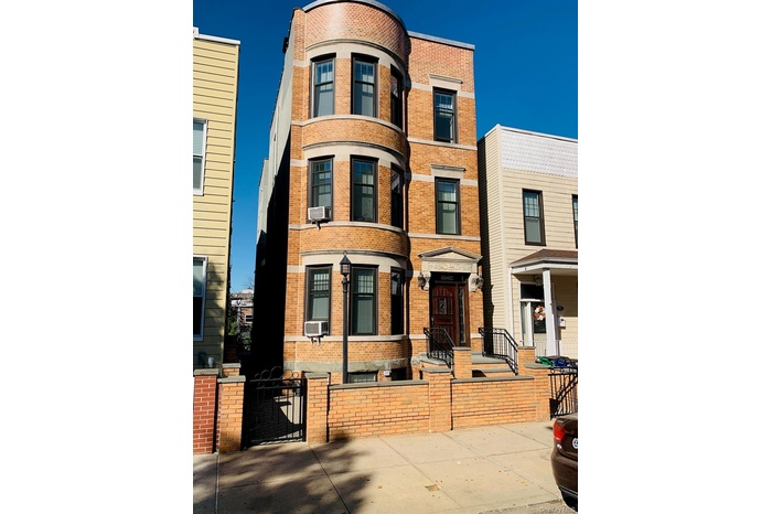 View of front facade with a gate, brick siding, and a fenced front yard
