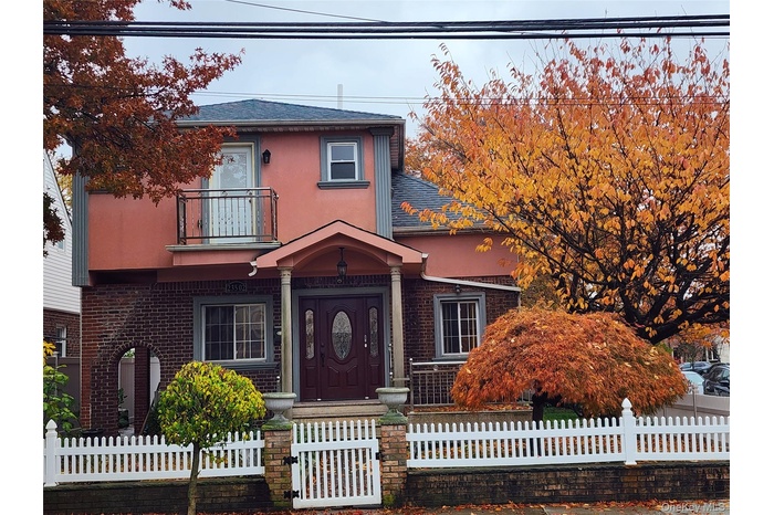 View of front of home featuring stucco siding, a fenced front yard, a balcony, and a shingled roof
