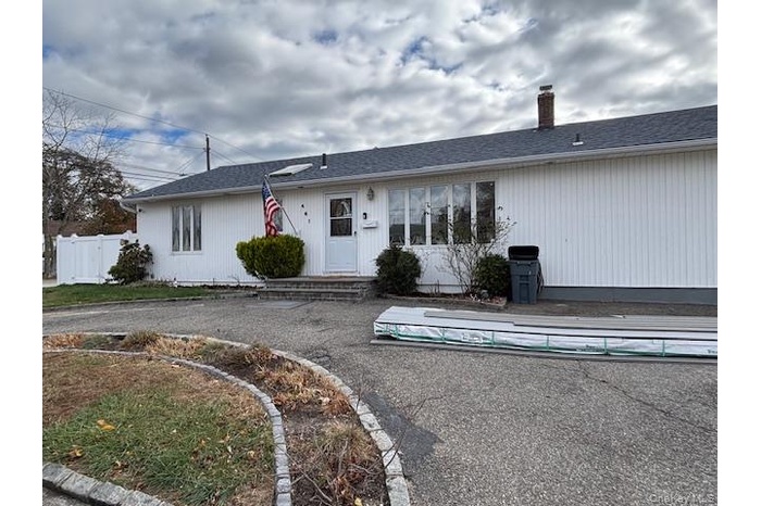 Single story home featuring a shingled roof and a chimney