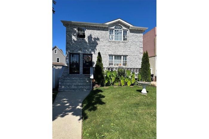 Traditional home with a front lawn and brick siding