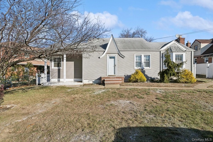 View of front of property with a gate and a shingled roof
