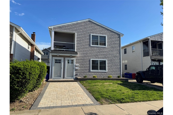 Traditional-style house with a front yard and a balcony
