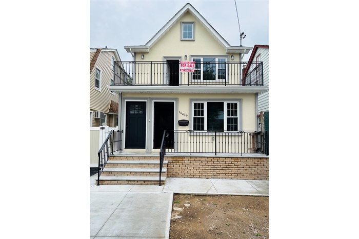 View of front of property with stucco siding and a balcony