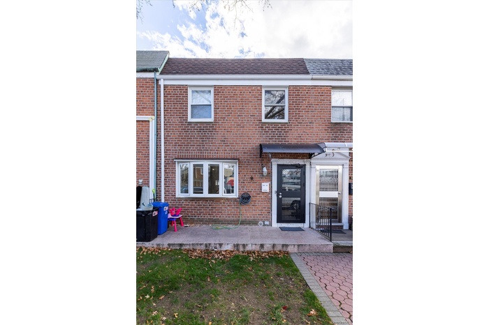 View of front of house with a shingled roof and brick siding
