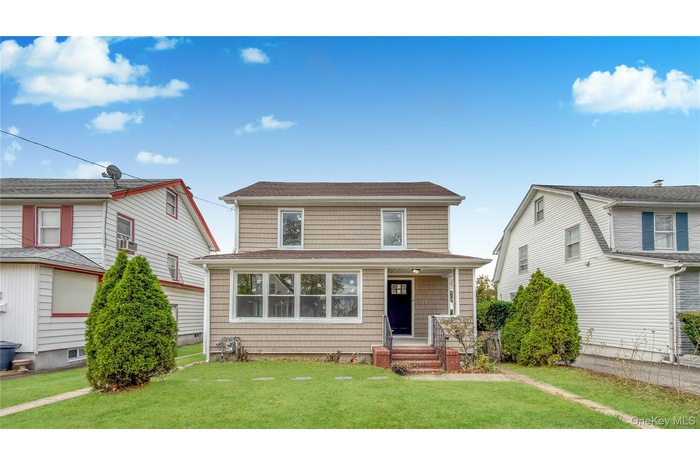 View of front of house featuring a front yard and roof with shingles
