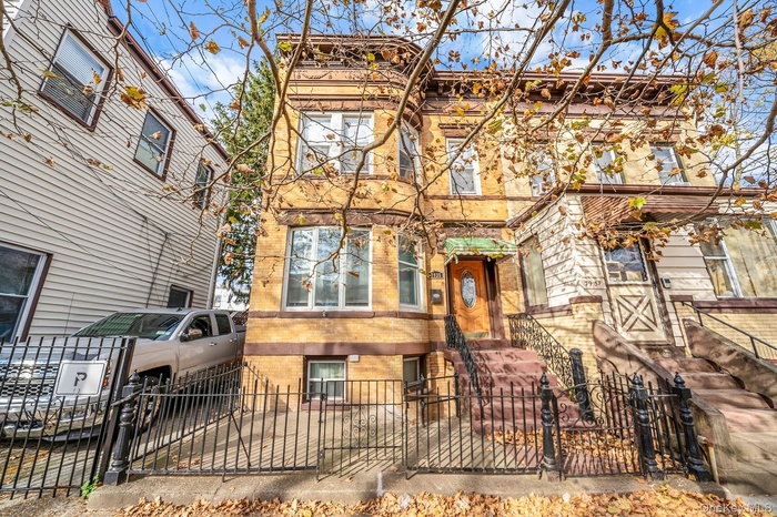 View of front facade featuring a fenced front yard, a gate, and brick siding