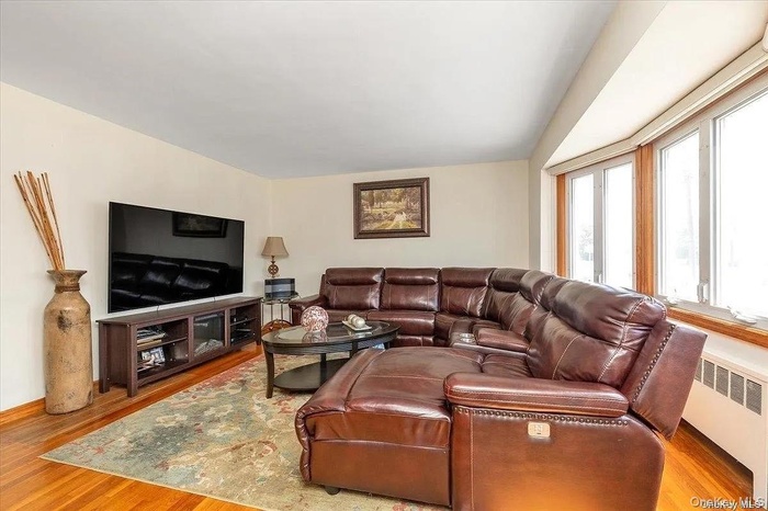 Living area with radiator and light wood-type flooring