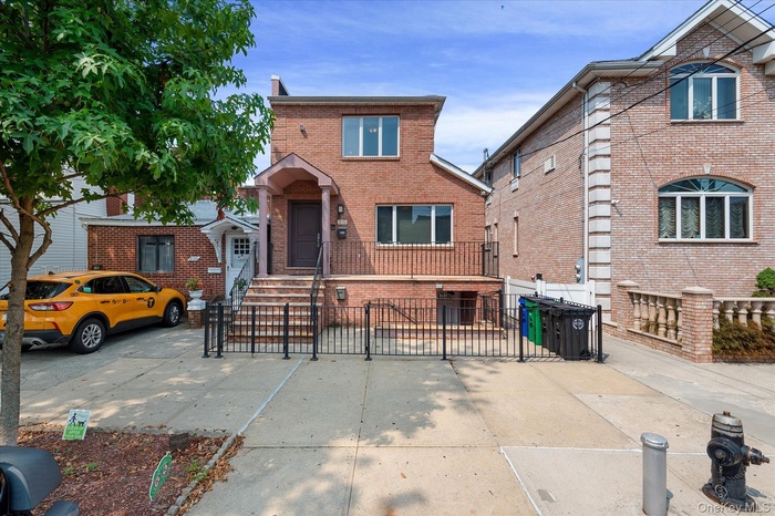 Traditional-style home featuring brick siding and a gate