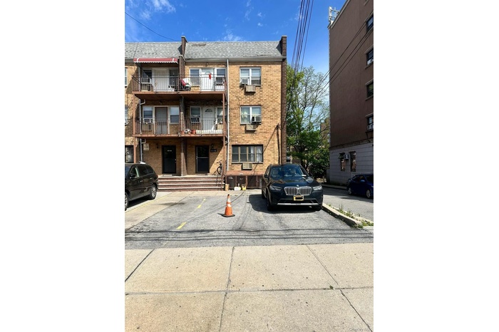 View of apartment building / complex featuring uncovered parking