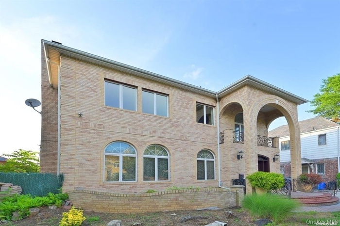 Back of property featuring brick siding and a balcony