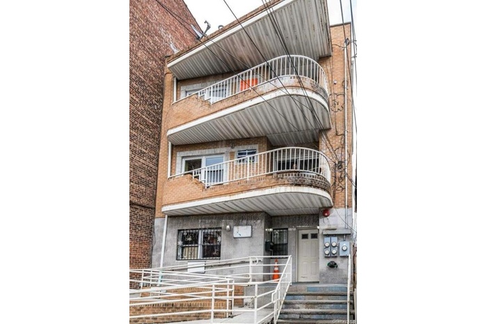 View of front of home featuring a balcony and brick siding
