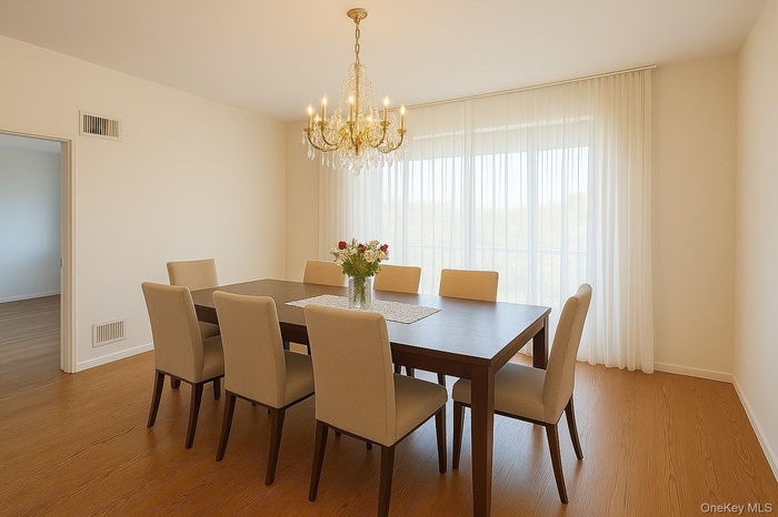 Dining area featuring light wood finished floors and a chandelier