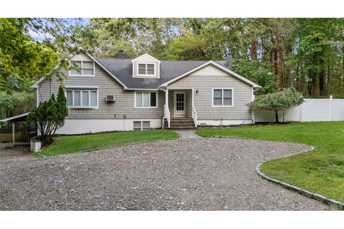 Back of house with a chimney, roof with shingles, a wall unit AC, and entry steps