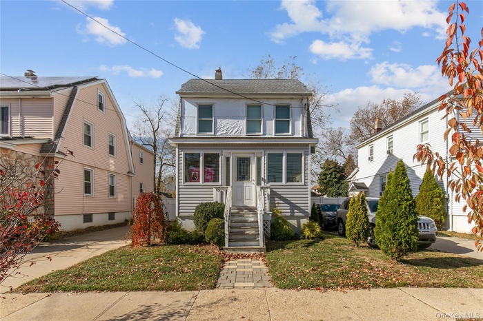 View of front of home featuring a chimney and a front lawn