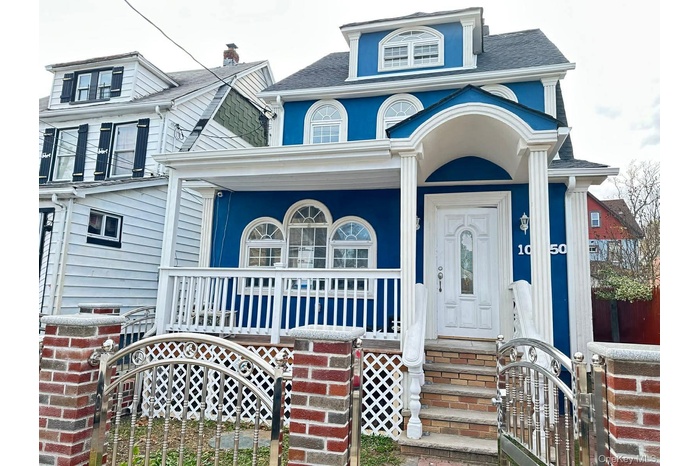 View of front of home featuring a gate, covered porch, and a shingled roof