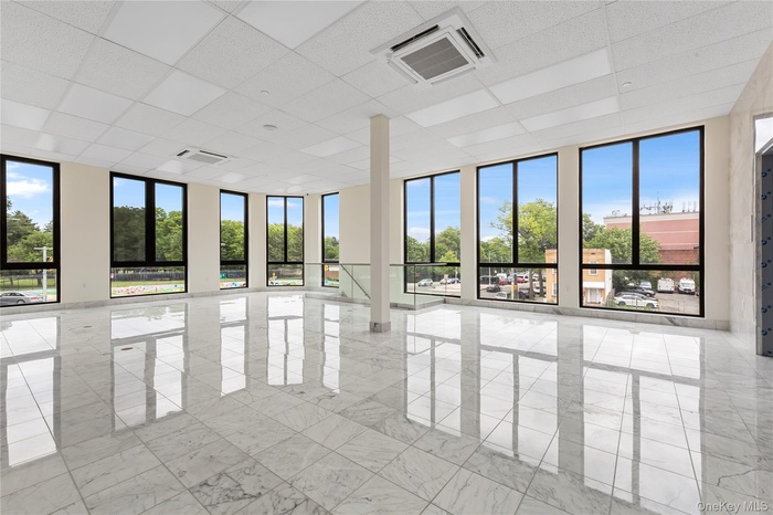 Empty room with a drop ceiling and marble finish flooring