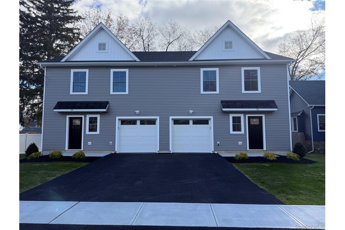 View of front of home featuring a standing seam roof, board and batten siding, a front yard, and a metal roof