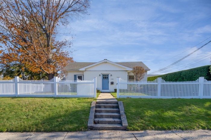 Bungalow-style home featuring a fenced front yard and roof with shingles