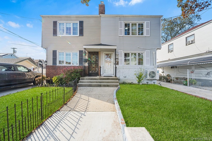 Traditional home featuring a fenced front yard, brick siding, and a chimney