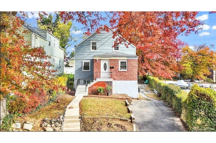 Bungalow-style home with brick siding and a front lawn