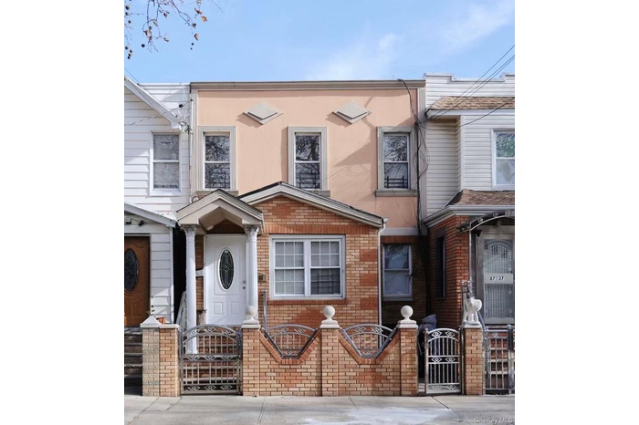 Traditional-style home featuring a gate, a fenced front yard, stucco siding, and brick siding