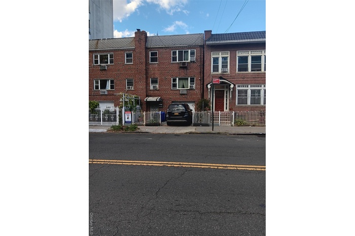 View of front of house with brick siding and a fenced front yard