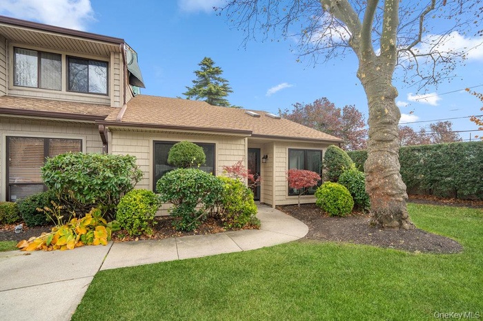 View of front of home featuring a shingled roof and a front yard