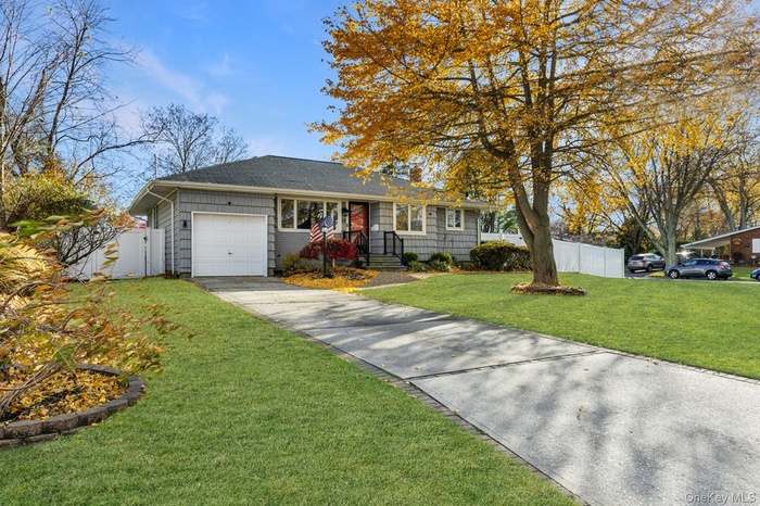 Ranch-style home featuring an attached garage, driveway, and a shingled roof