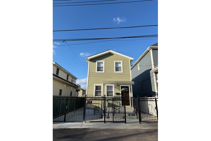 Traditional-style home featuring a fenced front yard and a gate