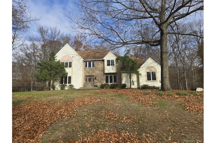 Traditional home with a front lawn and brick siding