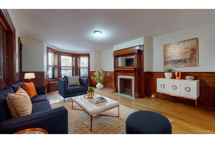 Living room with wainscoting, a fireplace with flush hearth, wood finished floors, and wooden walls