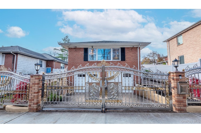View of front facade with a gate and brick siding