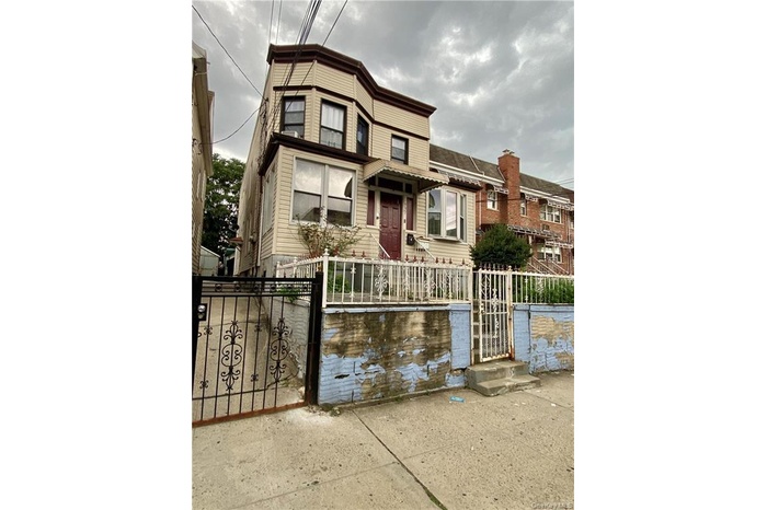 View of front facade with a fenced front yard and a gate