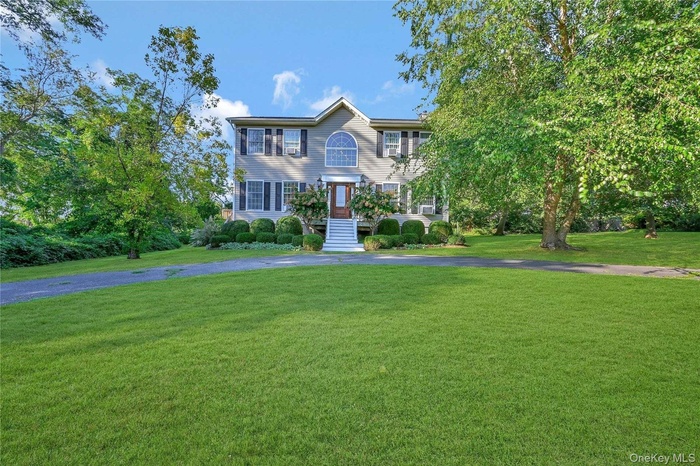 Colonial house with a front yard and driveway