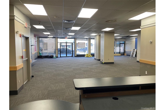 Common area featuring a paneled ceiling and a wall of windows