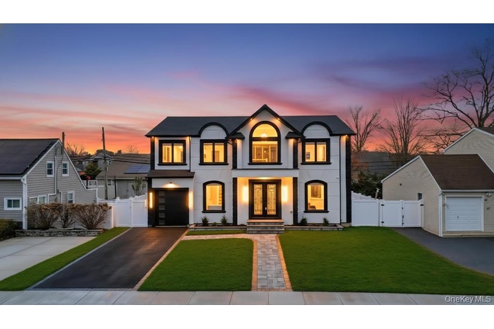 French provincial home with a gate, stucco siding, driveway, and french doors