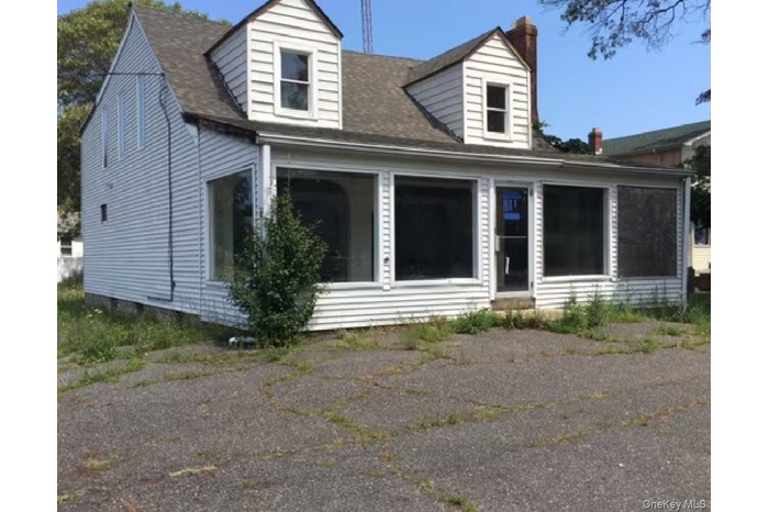 Cape cod home featuring a chimney, a sunroom, a shingled roof, and crawl space