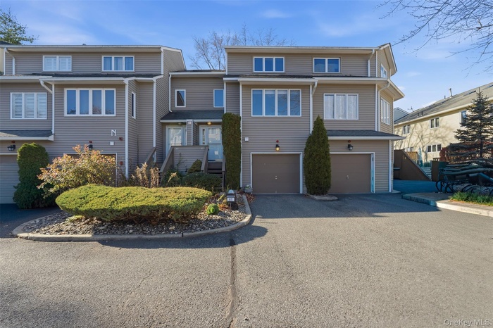 View of front of property with asphalt driveway and a garage