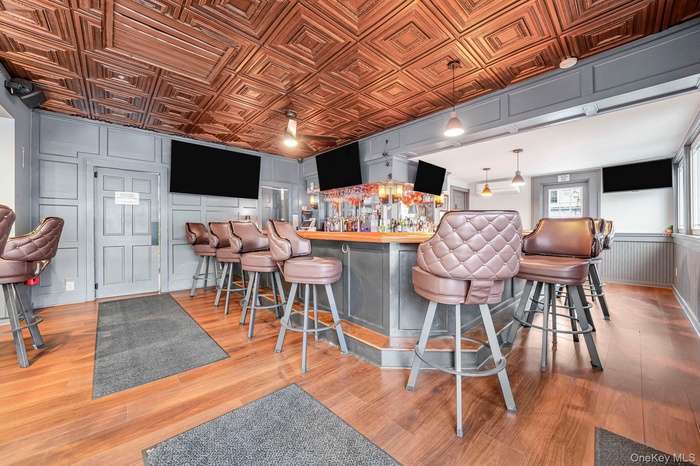 Indoor dry bar featuring an ornate ceiling, a decorative wall, and decorative light fixtures