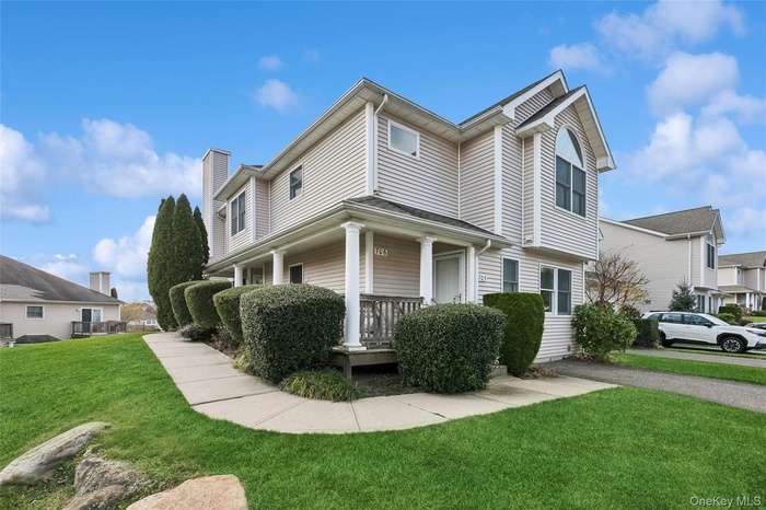 View of property exterior featuring a lawn, a porch, and a chimney